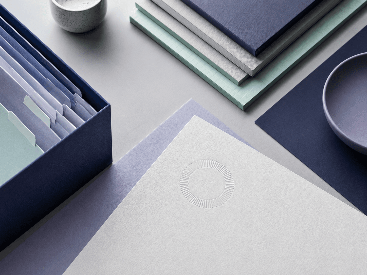 An embossed circular blind-pressed seal on thick pale cotton paper